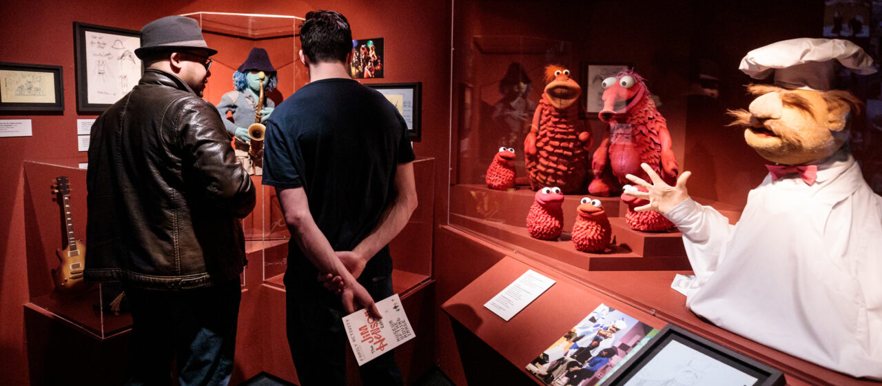 Jim Henson Exhibition visitors walk through an exhibit