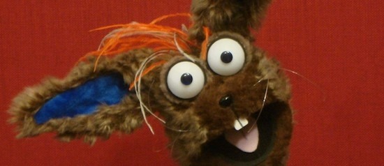 A puppet named Silly Willy in extreme closeup, smiling at camera with open mouth