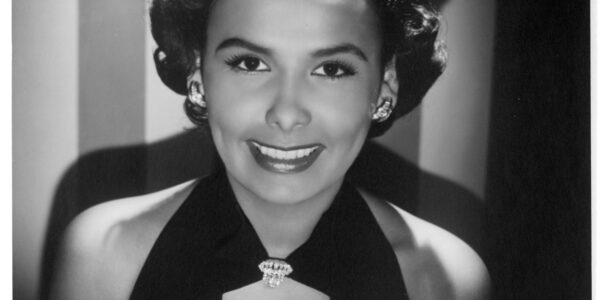 Medium close-up of the star Lena Horne in black and white, looking at camera