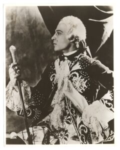 Rudolph Valentino in a white wig, showing his left side profile