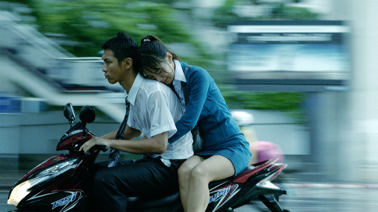 A man and a woman on a motorcycle in motion