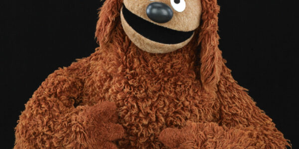 The puppet Rowlf, with brown fur, smiling and looking at camera