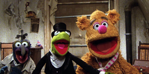 Three muppets, Gonzo, Kermit, and Fozzie Bear look at the camera, their mouths open