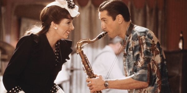 A man playing a saxophone and a woman smiling at him