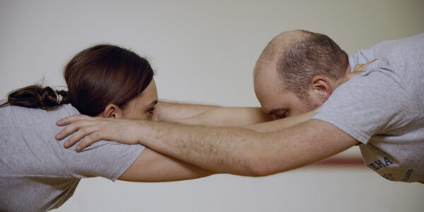 A man and women stretch and lock arms