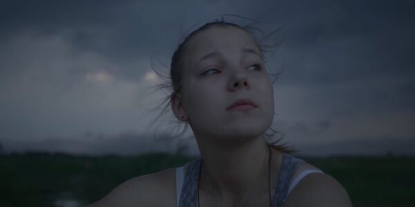 A young woman looks out into the gray sky