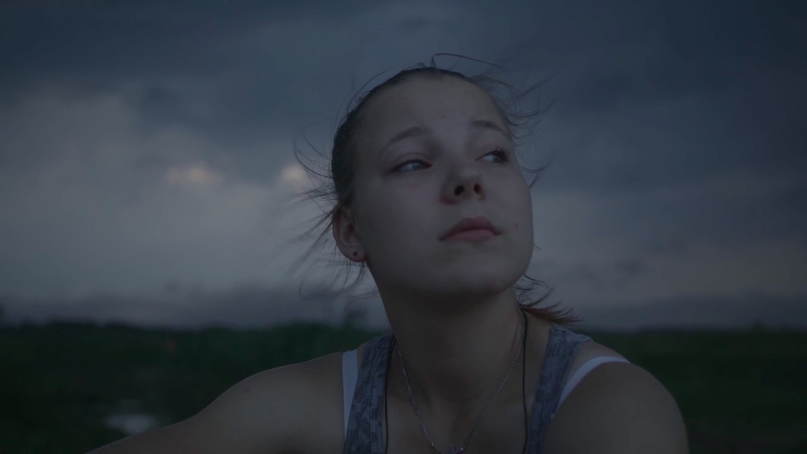 A young woman looks out into the gray sky