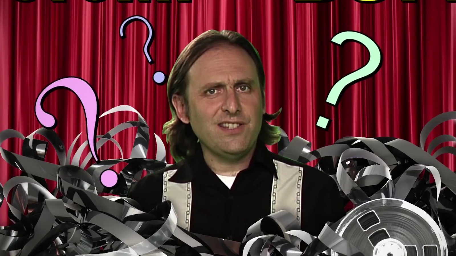A goofy man looking into camera and surrounded by question marks and film reel cans
