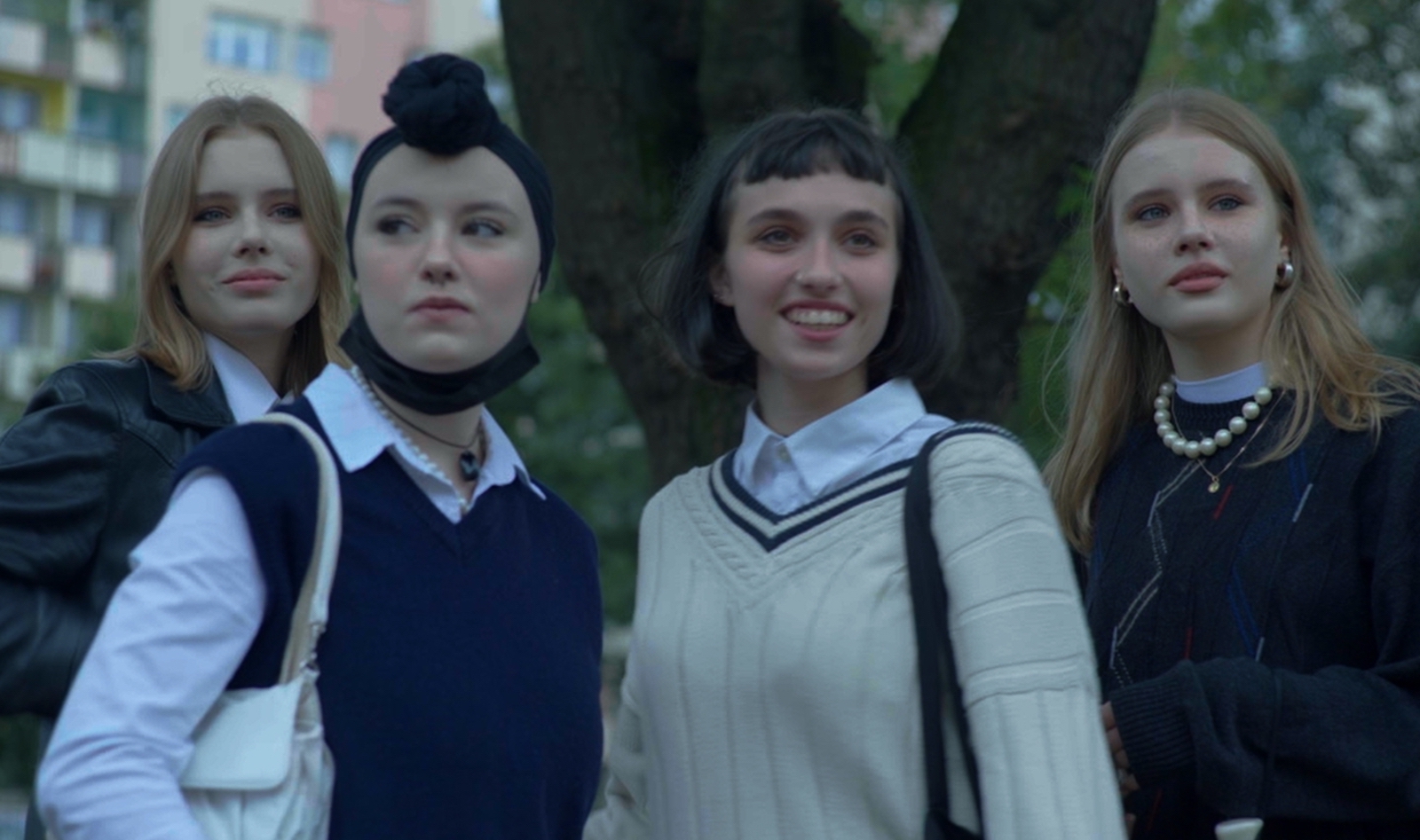 Four teenage girls look towards camera