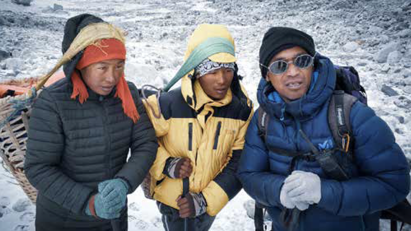 Three men wearing heavy coats for a climbing expedition