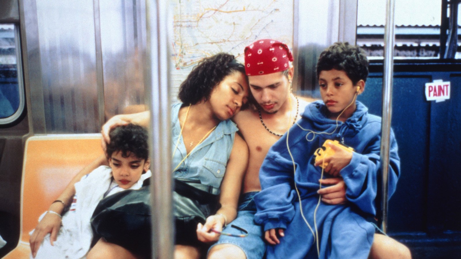 A husband and wife hold their two kids as they sit on the New York City subway