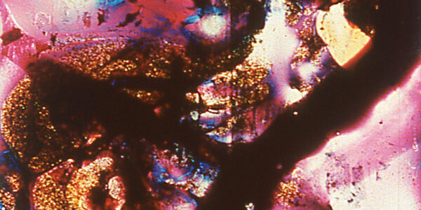 An abstract image of pink, blue, and gold paint on glass