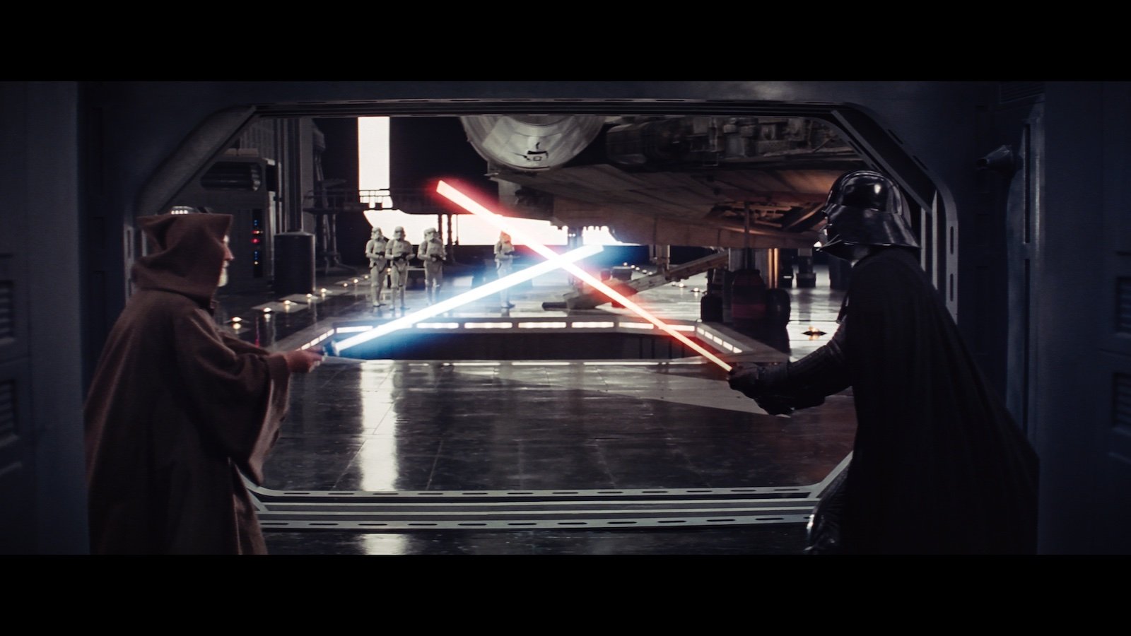 a man in a cloak and a man in a dark helmet and cape fight with light sabers