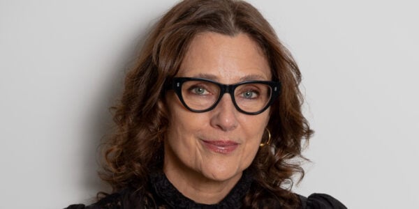 A woman with glasses looks at camera