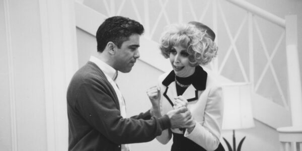 A black and white shot of a man and woman on a sitcom set fighting