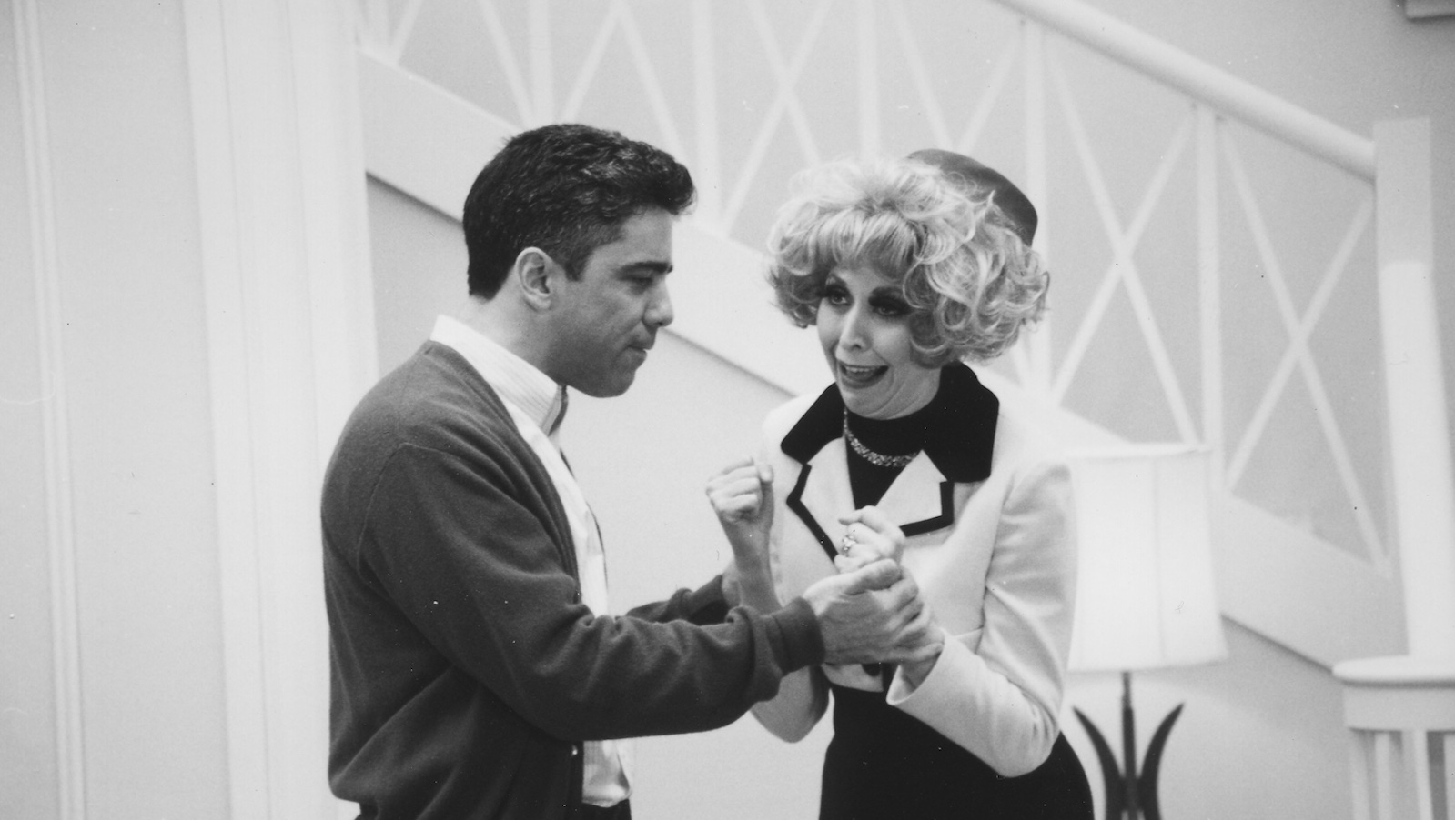 A black and white shot of a man and woman on a sitcom set fighting
