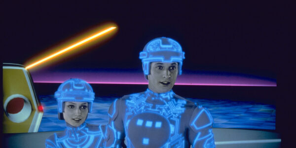 two people with glowing body suits and helmets stand in a sparse virtual world