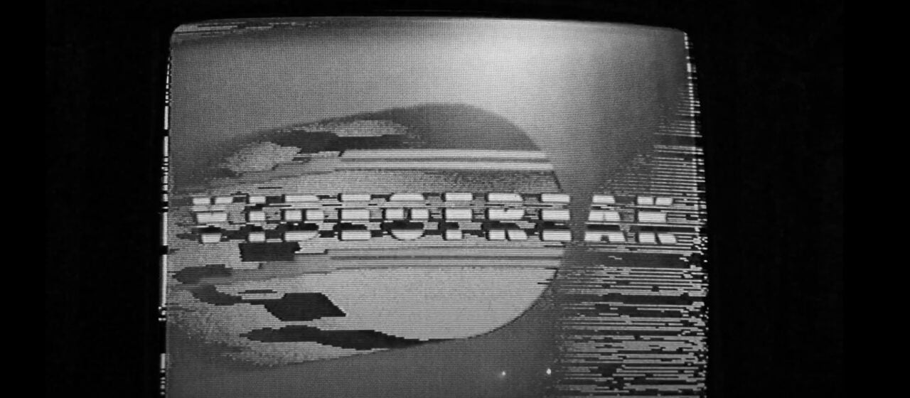 A black and white television screen scrambled by tracking issues, with the words VIDEOFREAK obscured by wavy lines