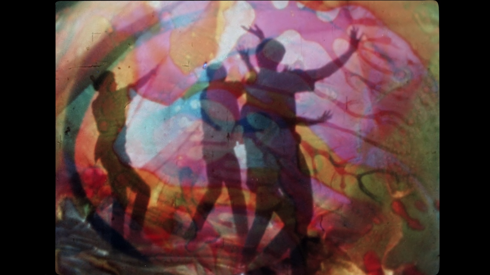 Silhouettes of people dancing against psychedelic color bubbles