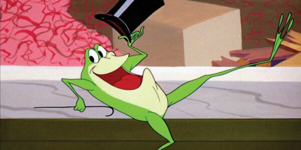 A cartoon frog dancing with a cane and top hat, mouth open smiling at camera.