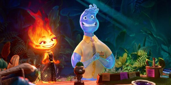 An animated image of an orange figure with a fiery head meant to represent the element fire standing at a table aside a blue figure with a liquid head meant to represent the element water; the fire character is featured as feminine, the water character is designed as traditionally male. Both smile, though the fire figure looks at the water figure, who looks away awkwardly.