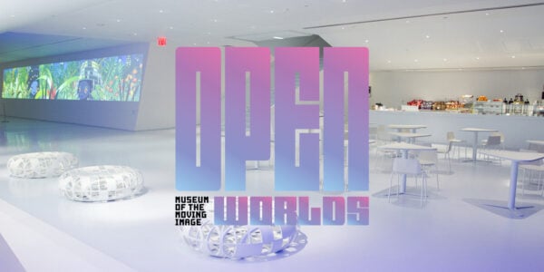 A square-shaped logo with the words OPEN WORLDS in bright pastel colors that start with pink at the top and gradient into blue by the bottom. In the lower-left corner is the much smaller, square-shaped logo reading the words Museum of the Moving Image. It is hovering over an image of an all-white Museum of the Moving Image lobby.